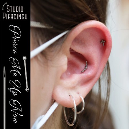tytanowy labret z clusterem z malutkich kuleczek, tworzących łuk zaprezentowany w przekłuciu conch