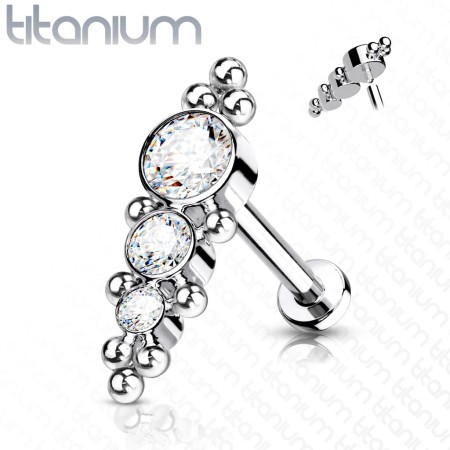 Tytanowy labret Crystal Balls z clusterem 3 kryształków połączonych małymi kuleczkami. Pręt 1,2 mm z gwintem wewnętrznym 0,9 mm, nakrętka 13,3 mm. Idealny na świeże przekłucie, dla alergików na nikiel. Pasuje do helix, lobe, conch.