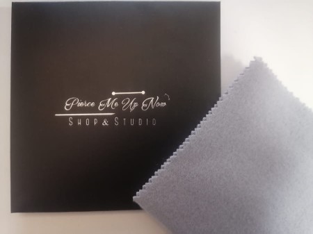 Ściereczka z miękkiej bawełny, skutecznie czyści kolczyki na wysoki połysk. Nasączona substancją ochronną, zapobiega utlenianiu biżuterii. Uwaga: chronić przed dziećmi!