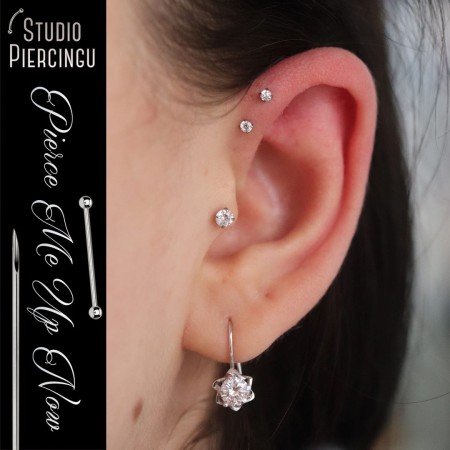 Labrety z białymi cyrkoniami o różnych wielkościach cyrkonii pokazane w przekłuciu tragus oraz dwóch forward helix
