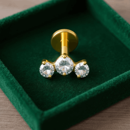 Trzy białe cyrkonie kubiczne zostały osadzone w klasycznej oprawie łapowej (krapowej). Smukłe łapki trzymają kamienie w sposób, który podkreśla ich krystaliczną czystość i pozwala światłu efektownie się w nich załamywać.