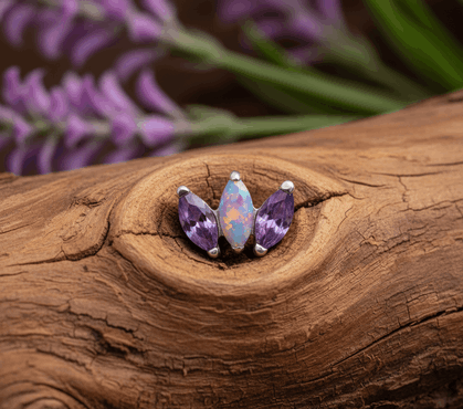 Nakrętkę zdobią trzy kamienie w szlifie markiza: centralnie umieszczony syntetyczny opal w intensywnym fiolecie mieni się wielowymiarowym blaskiem, a po jego bokach znajdują się fioletowe cyrkonie kubiczne, tworząc harmonijną i elegancką kompozycję.