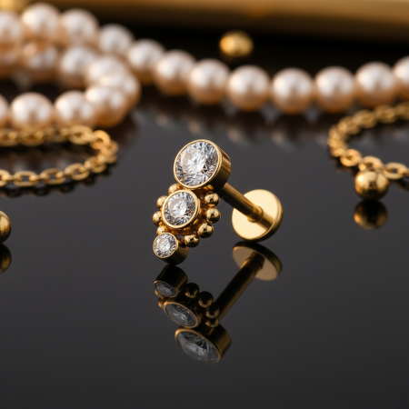 Labret Gold Dropdown z trzema cyrkoniami i minimalistycznymi kuleczkami, długość nakrętki 9 mm. Idealny do lobe, helix, conch i tragus. Wykonany ze stali chirurgicznej 316L z powłoką PVD, z gwintem wewnętrznym.