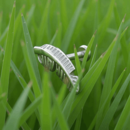 Tytanowy labret z misternym piórkiem 11,2 mm, hipoalergiczny i trwały.