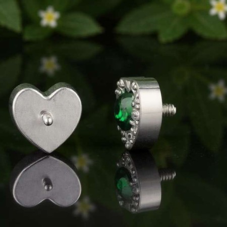 Centralny kamień otacza subtelna kompozycja 11 drobnych, krystalicznie białych cyrkonii, tworzących wokół niego świetlistą oprawę