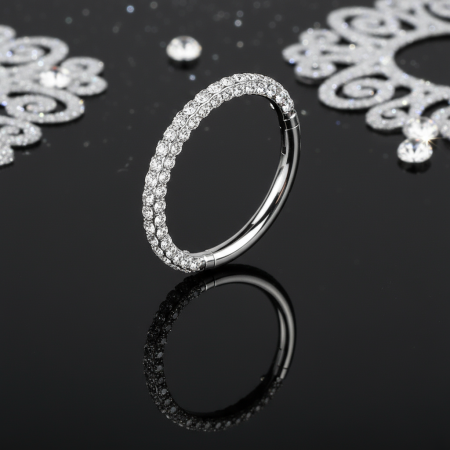 Tytanowy clicker. Cyrkonie lśnią z każdej strony – od góry, z boku i od dołu – tworząc efekt prawdziwego blasku 360°, który przyciąga spojrzenia.