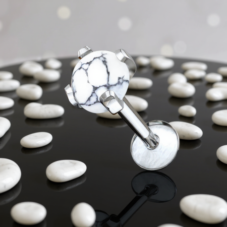 Subtelny labret ozdobiony howlitem o średnicy 4 mm, kamieniem w mlecznobiałym kolorze, często zdobionym naturalnymi ciemnymi żyłkami.