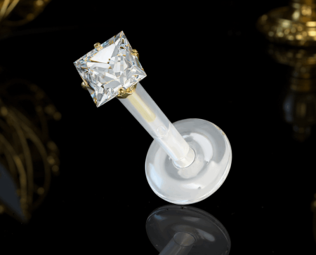 Labret z bioflexu z białym kryształkiem 3D w złotej kwadratowej oprawie.