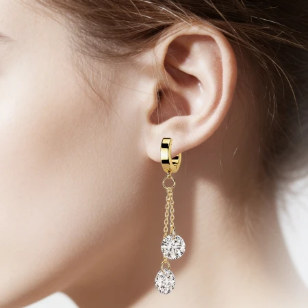 Kolczyk Huggie Double Crystal Dangling – stal chirurgiczna 316L Uroczy kolczyk typu huggie ozdobiony efektowną zawieszką składającą się z dwóch delikatnych łańcuszków zakończonych dużymi, lśniącymi białymi cyrkoniami sześciennymi.