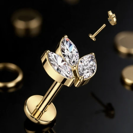Elegancki złoty labret tytanowy Marquise Queen zachwyca ozdobną kompozycją trzech cyrkonii o szlifie markiza. Wydłużony kształt kamieni nadaje biżuterii subtelnej elegancji, a złote wykończenie podkreśla ich blask.