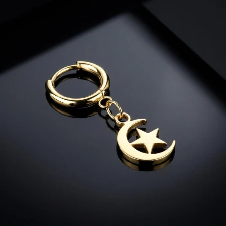 Wyjątkowe złote kółeczko Huggie Moon &amp; Star z zawieszką w kształcie księżyca i gwiazdy to idealna propozycja dla miłośników biżuterii inspirowanej kosmosem.