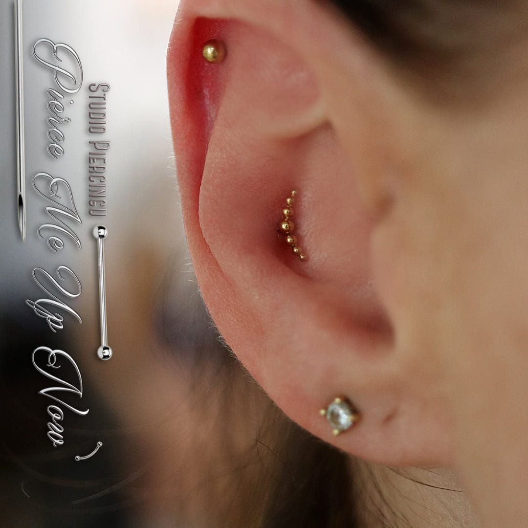 Tytanowy labret ze złotym clusterem z malutkich kuleczek, tworzących łuk zaprezentowany w przekłuciu conch