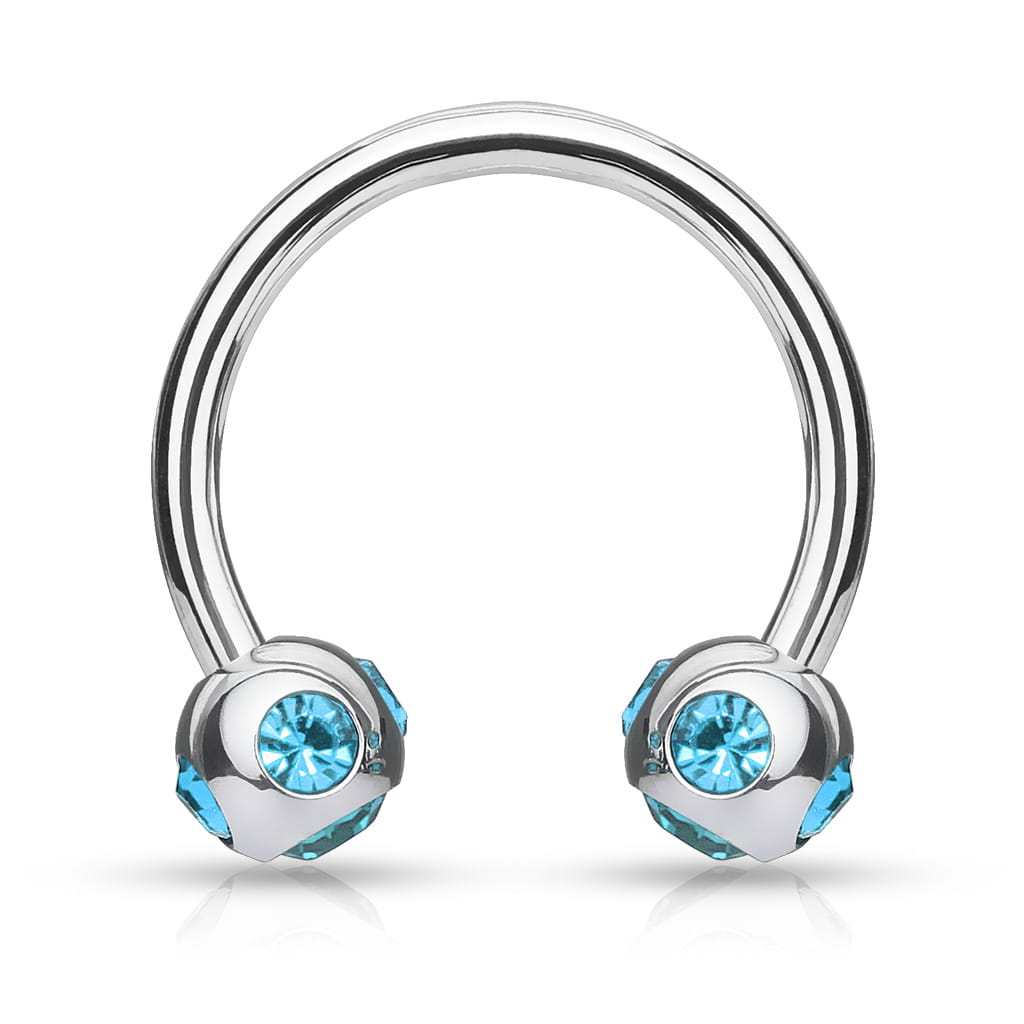 Podkówka z błękitnymi kryształkami umieszczonymi pod i po bokach kuleczek. Wykonana ze stali chirurgicznej 316L. Idealna do septum, daith i smiley. Gwint zewnętrzny.