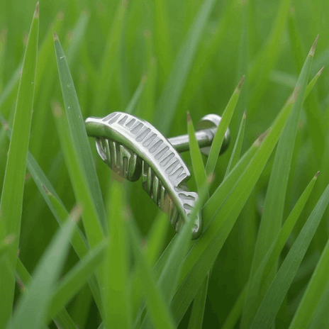 Tytanowy labret z misternym piórkiem 11,2 mm, hipoalergiczny i trwały.